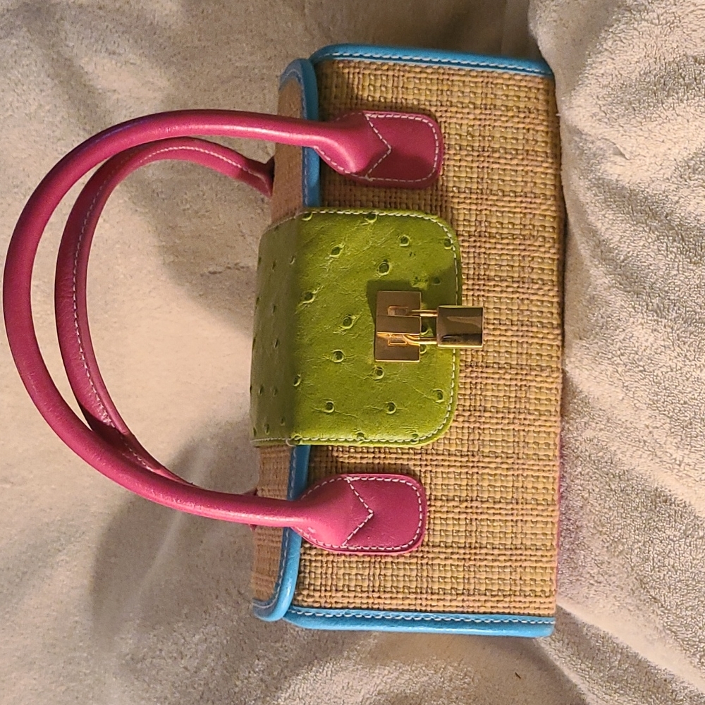 Small straw bag with bright vinyl trim. No interior or exterior pockets.